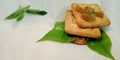 dry fruits mixture branded biscuits isolated on green leaves with white background