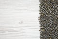 Dry green french lentils on a white wooden background, top view. Overhead, from above. Copy space