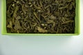 Dry green leaf tea in a yellow (lime) box, closeup Royalty Free Stock Photo