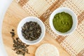 Dry green tea leaves and matcha powder in the small white bowls. Natural beauty treatment, skip-care or zero waste concept. Royalty Free Stock Photo