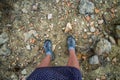 Legs of woman traveller standing on a ground of Cyprus island full of broken ancient pottery shards