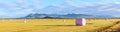 Dry hay bale in pink plastic film to stock for winter season with colorful mountains as a background