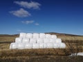 Dry hay bale in white plastic bag, Agriculture field on sunny sky,Rural nature in farm land,Straw on meadow,Wheat yellow golden h Royalty Free Stock Photo