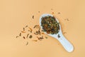 Dry herbal tea based on the petals of medicinal plants in spoon on orange background Royalty Free Stock Photo