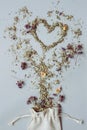 Dry herbal tea placed in the shape of heart on the gray background