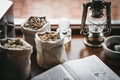 Dry herbs  old book in ancient pharmacy on wooden table Royalty Free Stock Photo