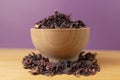 Dry hibiscus tea  in bowl on wooden board. violet background behind. herb. herbal tea. food ingredient Royalty Free Stock Photo