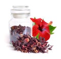 Dry hibiscus tea in glass jar with flower. Isolated on white background.