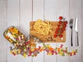 Dry Italian pasta fettuccini and farfalle with tomatoes, rosemary, mixture of peppers and glass jar Royalty Free Stock Photo