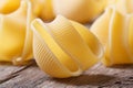 Dry Italian pasta lumaconi scattered on the old desk Royalty Free Stock Photo