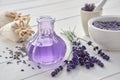 Dry lavender flowers, bottle of essential oil or flavored water, sachet and mortar on white table Royalty Free Stock Photo