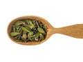 Dry leaves of Arctostaphylos in a wooden spoon on a white background