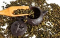 Dry leaves of tea tieguanyin, scattered around a porcelain teapot, a tea blade. Royalty Free Stock Photo