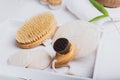 Dry lymphatic drainage massage wooden brushes and loofah pads for face and body skin care on a white tray background. Bathroom