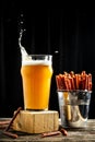 Dry Mini salami sticks with cold craft light beer in a glass with water drops. Dried snacks for beer Royalty Free Stock Photo