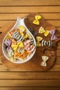 Dry multicolored Italian handmade macaroni called farfale, close-up in a white deep dish on a wooden background Royalty Free Stock Photo