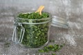 Dry parsley spice with wooden spoon in glass jar. Homegrown herbs and spices for cooking. Fresh dried aromatic natural