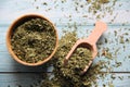 Dry parsley in a wooden bowl with a wooden measuring spoon on a wooden table. Royalty Free Stock Photo