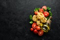 Dry pasta, tomatoes, greens, oil and ingredients. Italian traditional cuisine. Fresh vegetables. Top view. Royalty Free Stock Photo