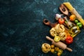 Dry pasta, tomatoes, greens, oil and ingredients. Italian traditional cuisine. Fresh vegetables. Top view. Royalty Free Stock Photo