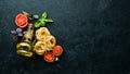 Dry pasta, tomatoes, greens, oil and ingredients. Italian traditional cuisine. Fresh vegetables. Top view. Royalty Free Stock Photo
