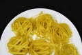 Dry pasta on a white plate. Wheat pasta