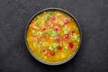 Dry Yellow Pea Soup with meat sausages, potato, green onions and sesame in black bowl at dark slate background Royalty Free Stock Photo