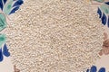 Dry pearl barley grain seed close up on colorful  bowl on table, top view Royalty Free Stock Photo