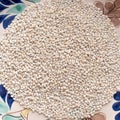 Dry pearl barley grain seed close up on colorful  bowl on table, top view Royalty Free Stock Photo