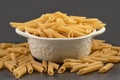 Dry penne pasta. Delicious pasta or penne noodles. Raw uncooked pasta penne in bowl. Raw pasta, macaroni, Penne alla vodka pasta. Royalty Free Stock Photo