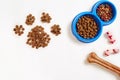 Dry pet food in bowl and bone on white background top view Royalty Free Stock Photo