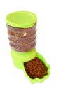 Dry pet food in green automatic pet feeder for dog and cat on white background