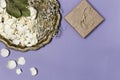 Dry petals of white roses and gypsophila on a beautiful antique tray, a gift wrapped in craft paper on a blue background. Place