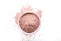 Dry pink clay powder mask for face and body in ceramic bowl