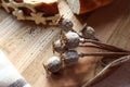 Dry poppy branches with scattered seeds on the background of a piece of white bread-the concept of using poppy seeds in cooking