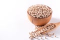 Dry raw brown tapioca pearls in a wooden bowl with spoon isolated on white background, close up, ingredient of making bubble boba Royalty Free Stock Photo