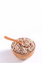 Dry raw brown tapioca pearls in a wooden bowl with spoon isolated on white background, close up, ingredient of making bubble boba