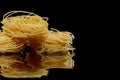 Dry, raw egg pasta capelli , isolated on black background. Cooking concept. Top view with copy space Royalty Free Stock Photo
