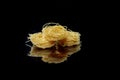 Dry, raw egg pasta capelli , isolated on black background. Cooking concept. Top view with copy space Royalty Free Stock Photo