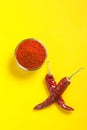 Dry Red chilli with chilli powder in glass bowl on yellow background Royalty Free Stock Photo