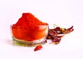Red chilly peppers and powder of dried chilies in a bowl isolated in the light background