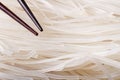 Dry rice noodles with chopsticks macro. Royalty Free Stock Photo