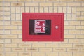Dry riser inlet box red on brick wall for emergency fire services water connection for hose brigade engine at shopping mall retail Royalty Free Stock Photo