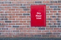 Dry riser inlet box red on brick wall for emergency fire services water connection for hose brigade engine at shopping mall retail Royalty Free Stock Photo