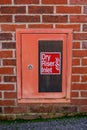A dry riser inlet cupboard in a brick wall Royalty Free Stock Photo