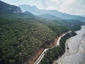 Dry river bed from aerial above. Street crossing sideway with beautiful green mediterrain trees on yellow sand. white Royalty Free Stock Photo