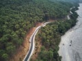 Dry river bed from aerial above. Street crossing sideway with beautiful green mediterrain trees on yellow sand. white Royalty Free Stock Photo