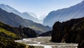 Almost dry river of nepal crosses a spectacular valley with the snowy annapurnas in the background and blue sky