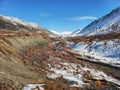 Dry riverbed in autumn in a mountain valley. The first snow in the mountains. Sunny beautiful day, mountain landscape Royalty Free Stock Photo