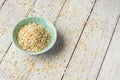 Dry rolled oatmeal in bowl on white wooden background. Top view. Royalty Free Stock Photo